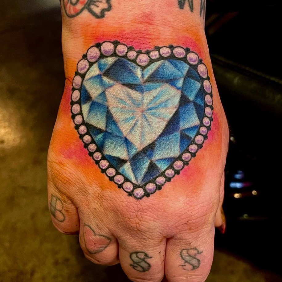 Heart shaped diamond tattoo on a hand