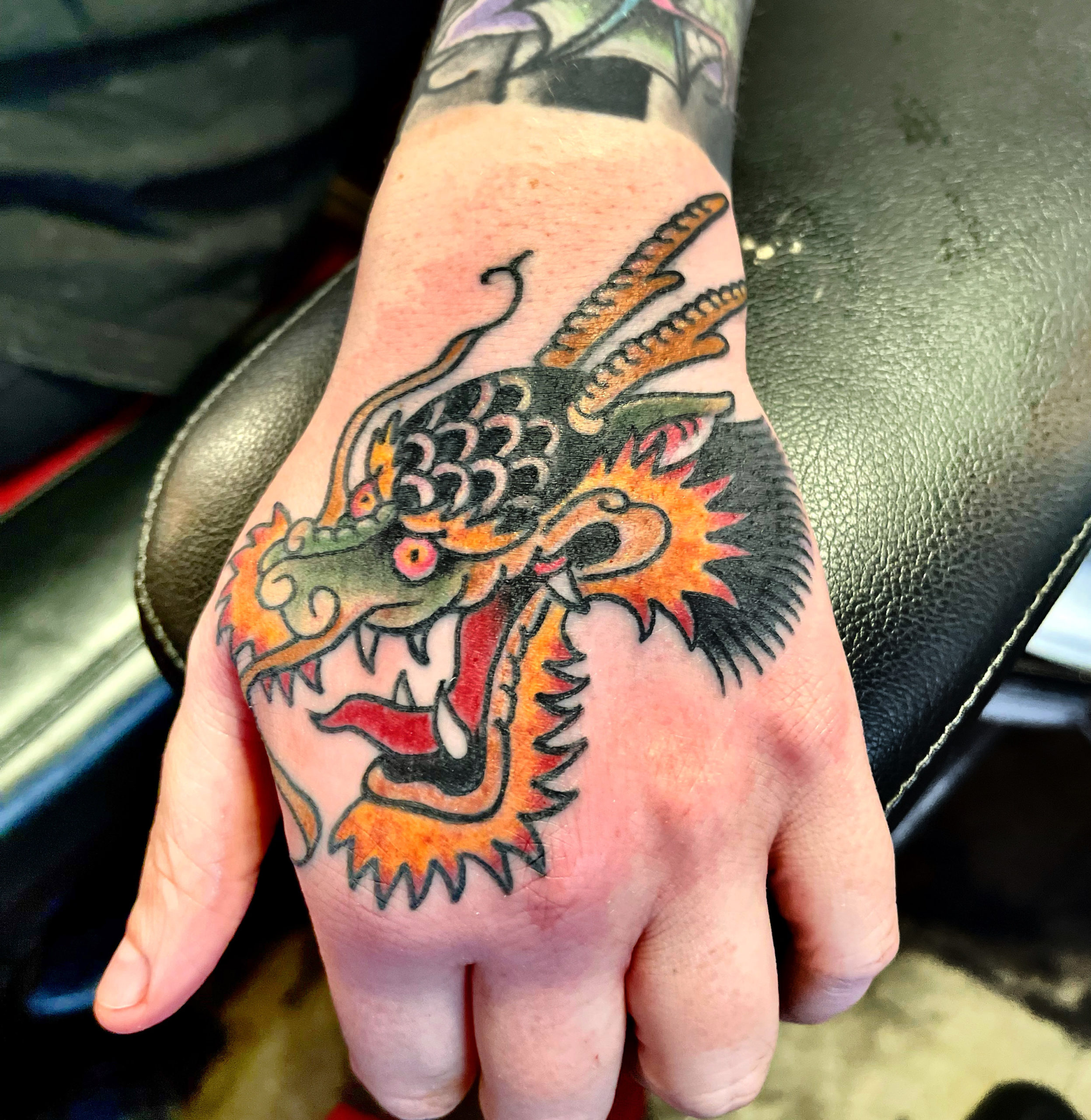 Dragon tattoo on a hand from top tattoo artists in dallas