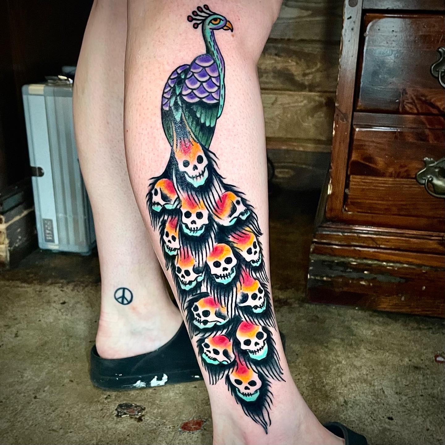 Tattoo of skulls and a peacock