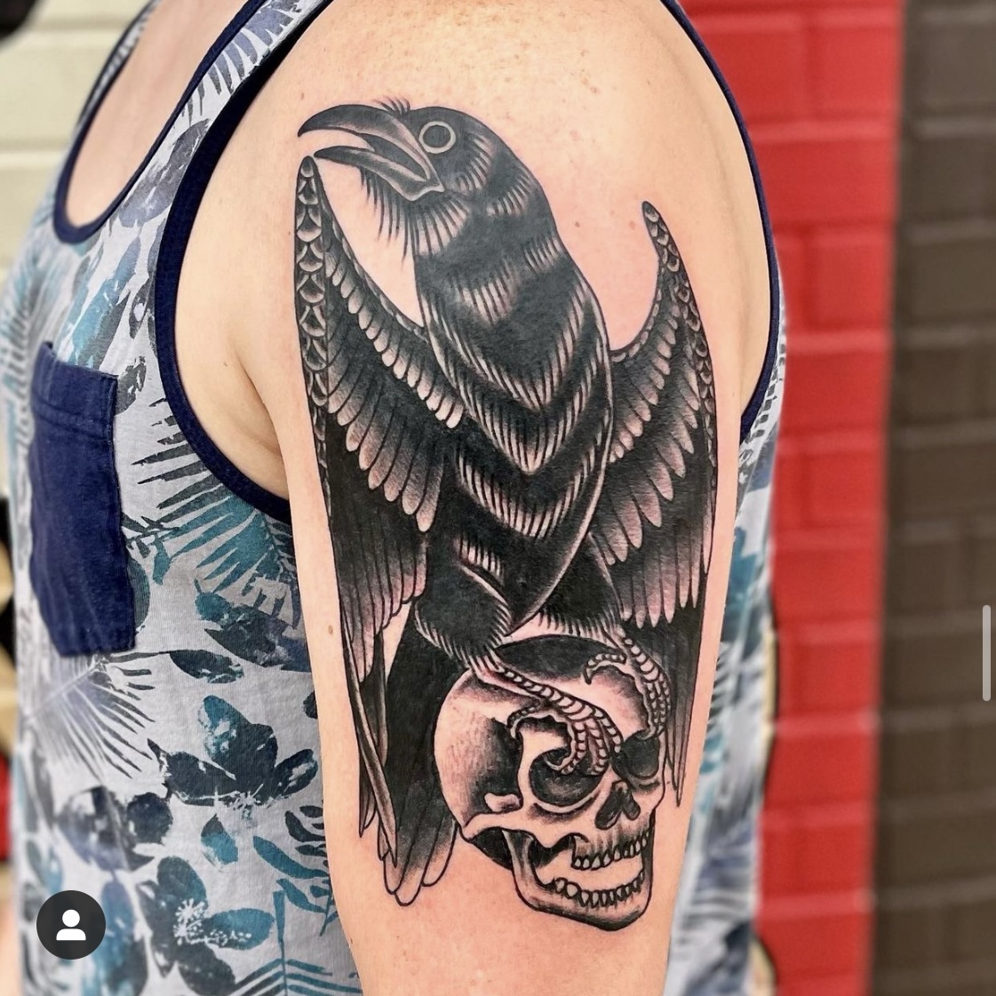 Tattoo of a skull and a raven on a man's arm