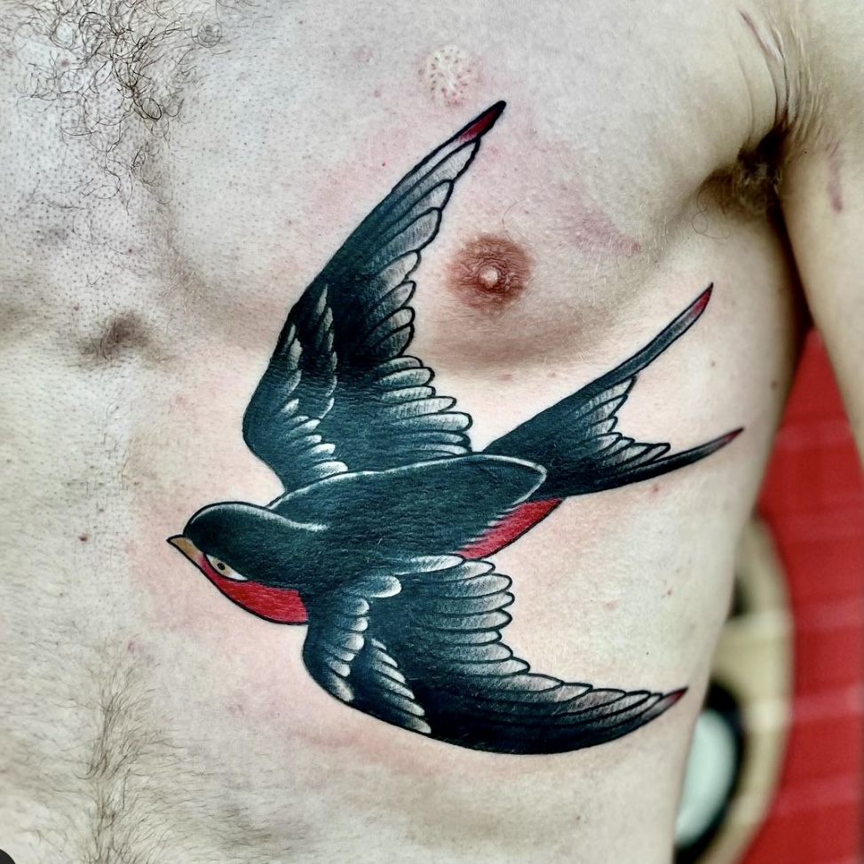 Tattoo of a black and red bird from local shop in Dallas Texas