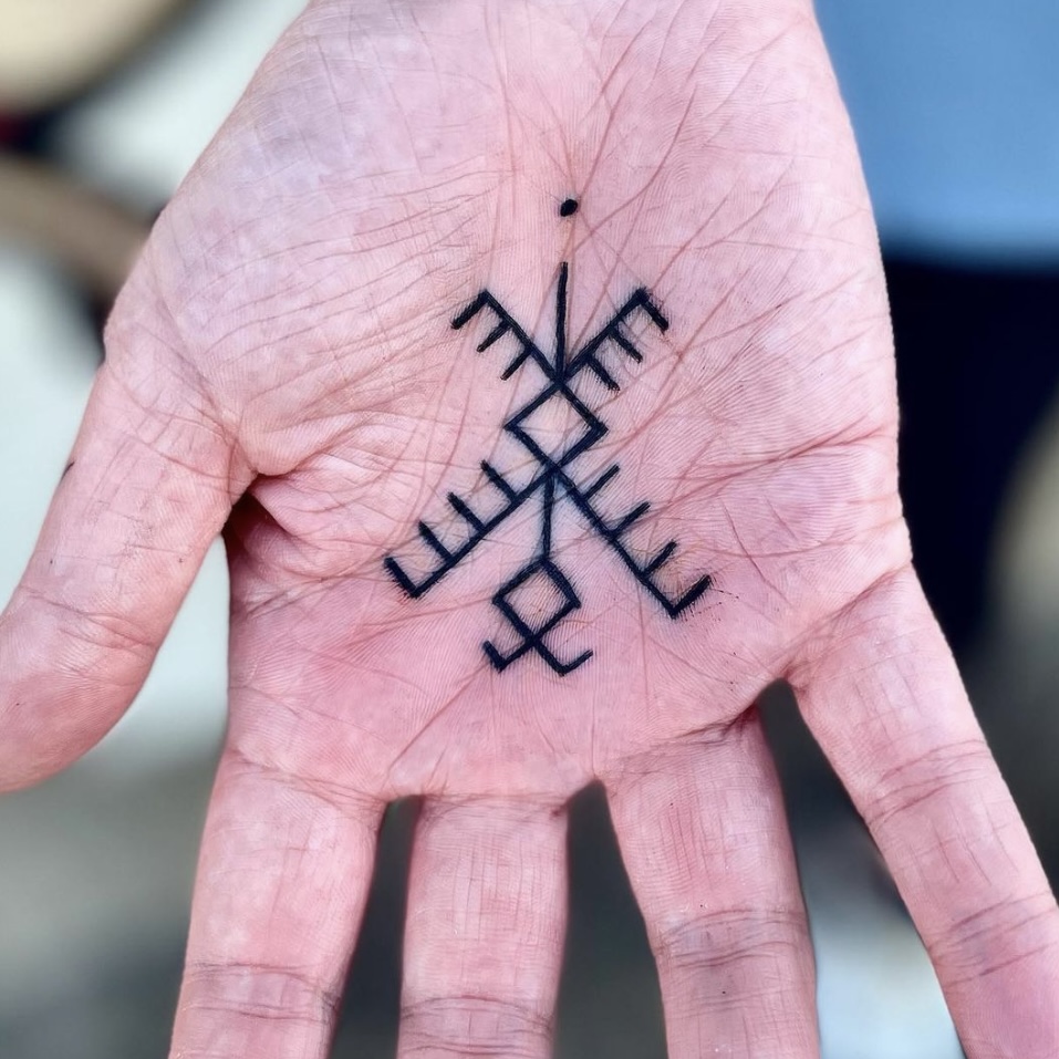 Symbol tattoo on the palm of a man's hand