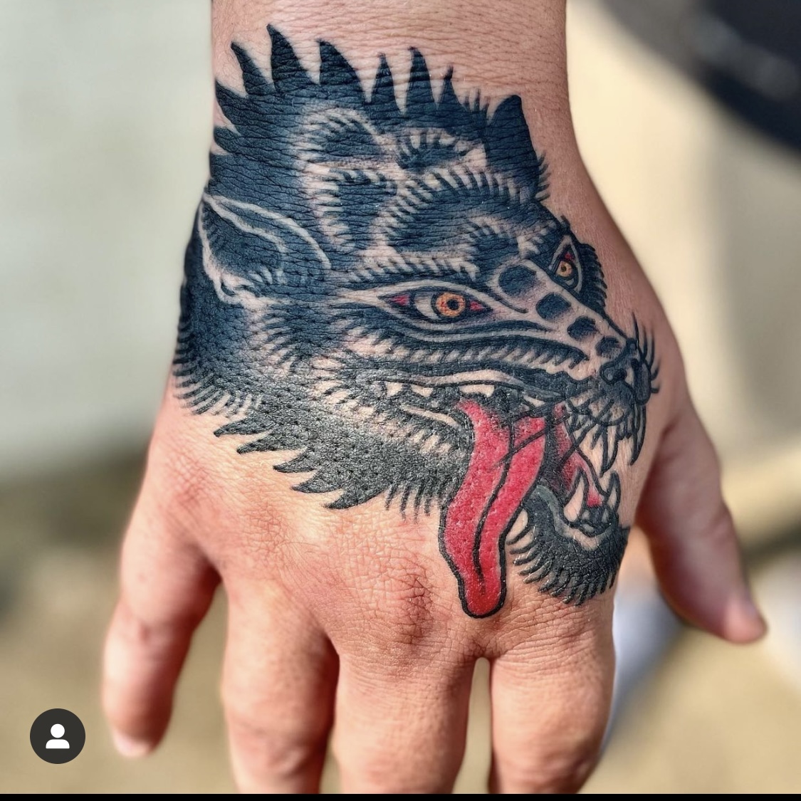 Tattoo of a wolf on a man's hand