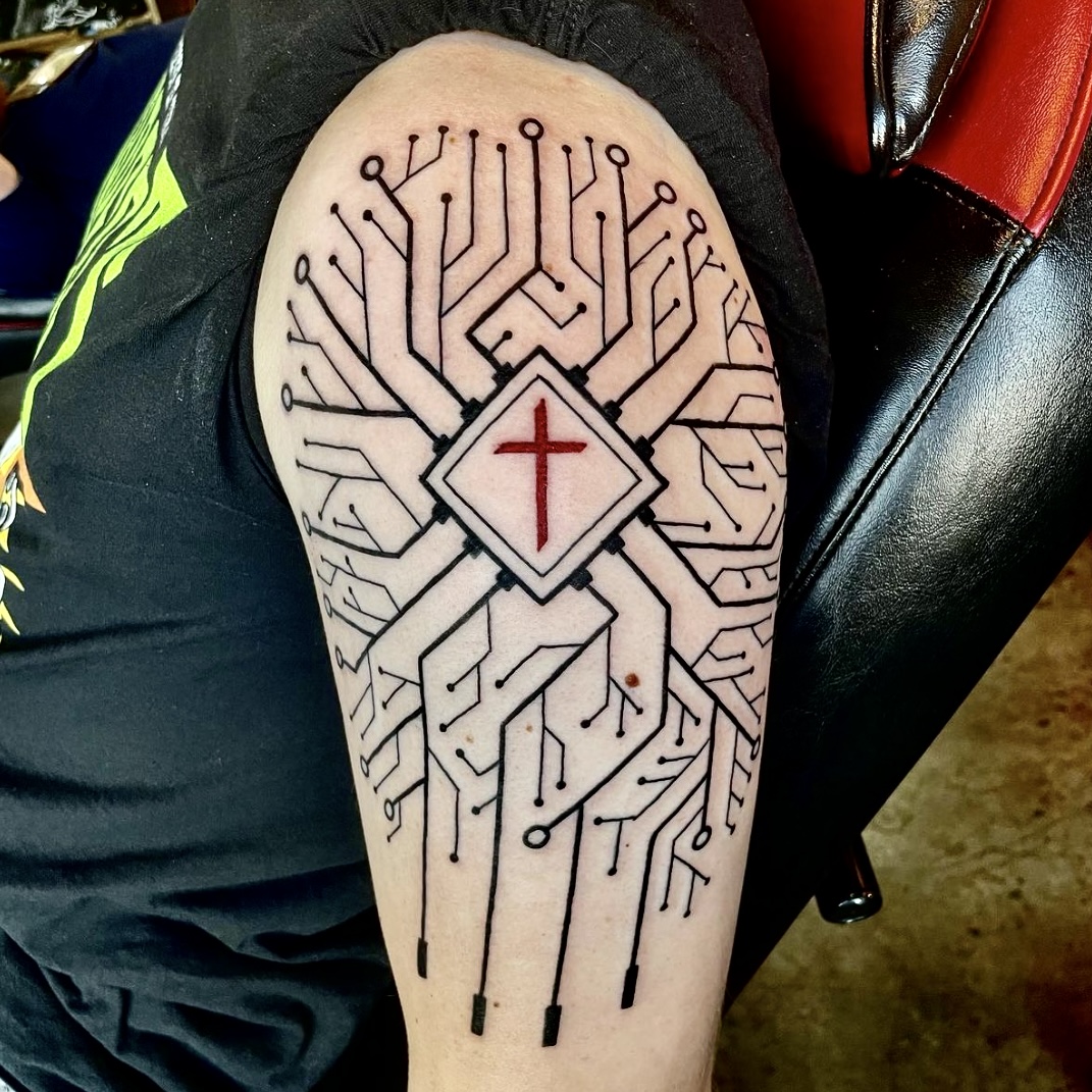 Tattoo of a cross with a design around it