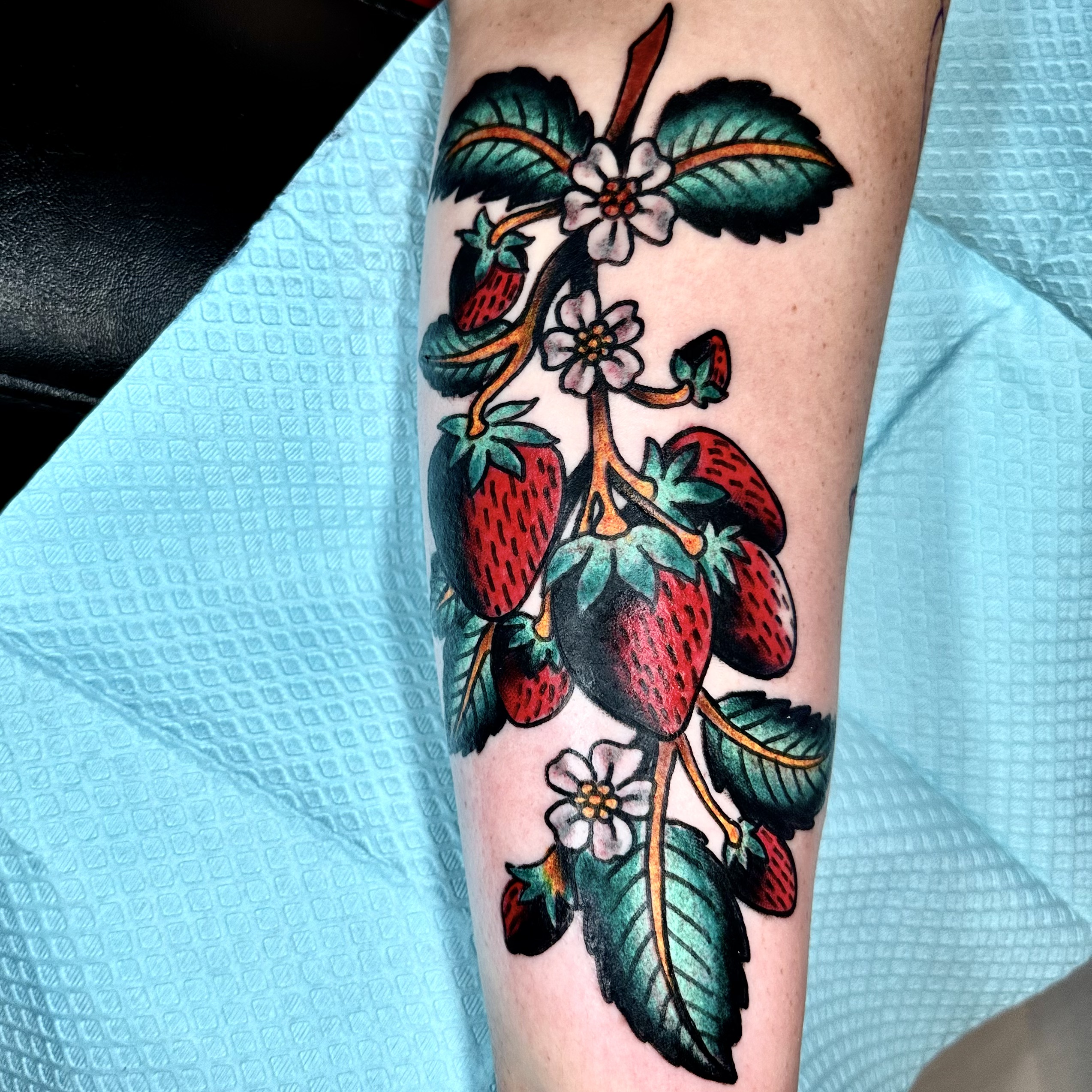 Tattooing of strawberries on a person’s arm