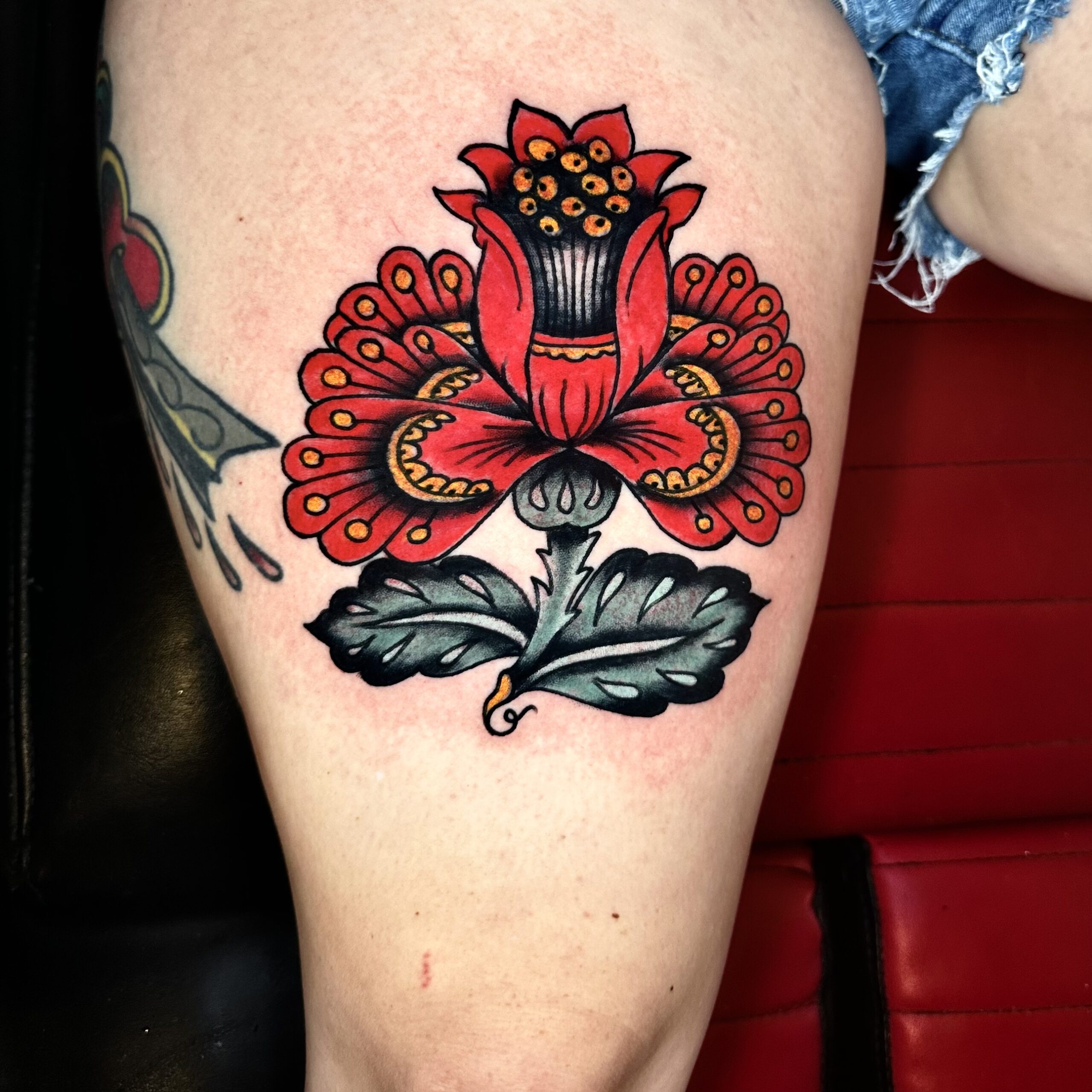 tattoo of a red flower from a tattoo shop in Dallas Texas