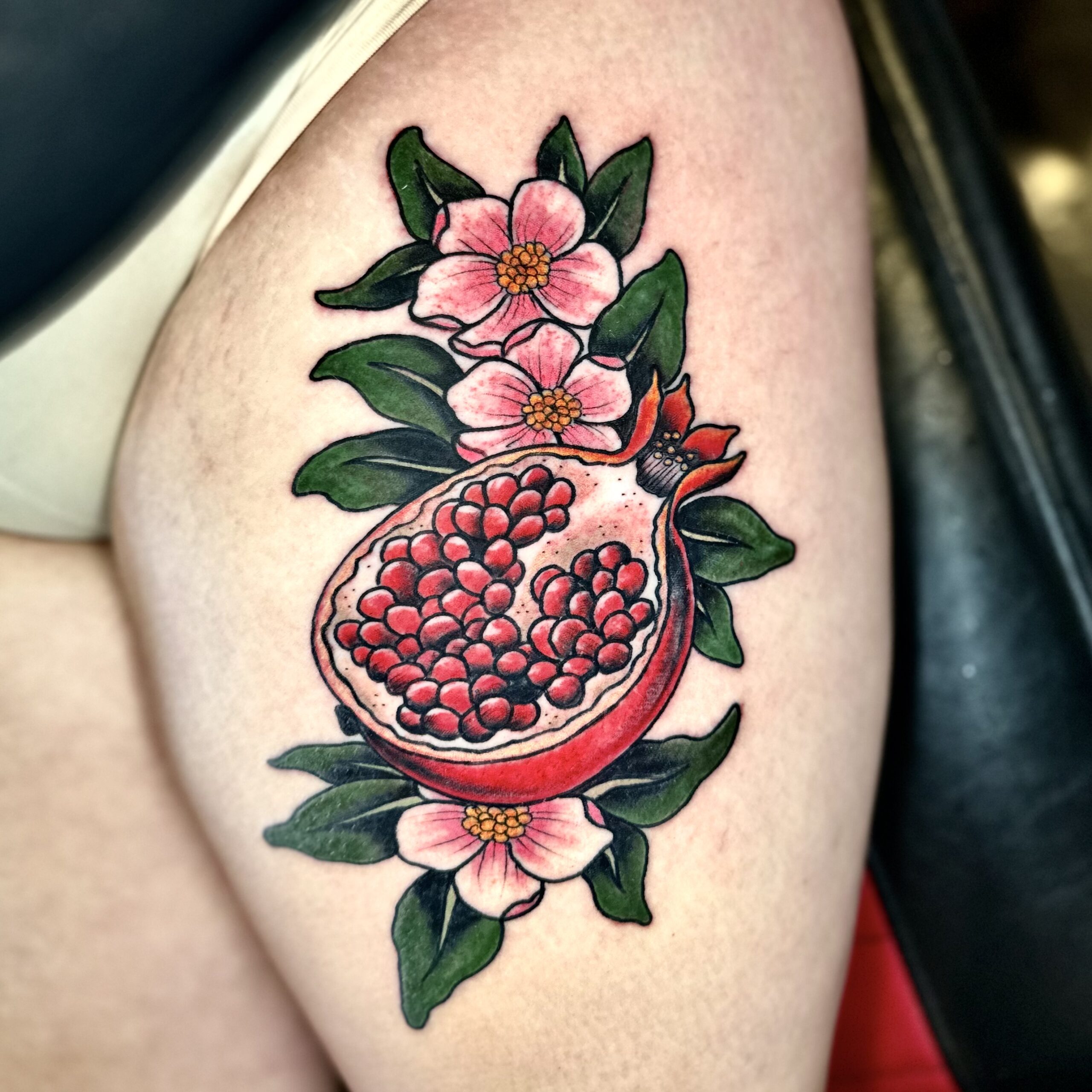 Tattoo of a pomegranate and some flowers from DFW tattoo shop