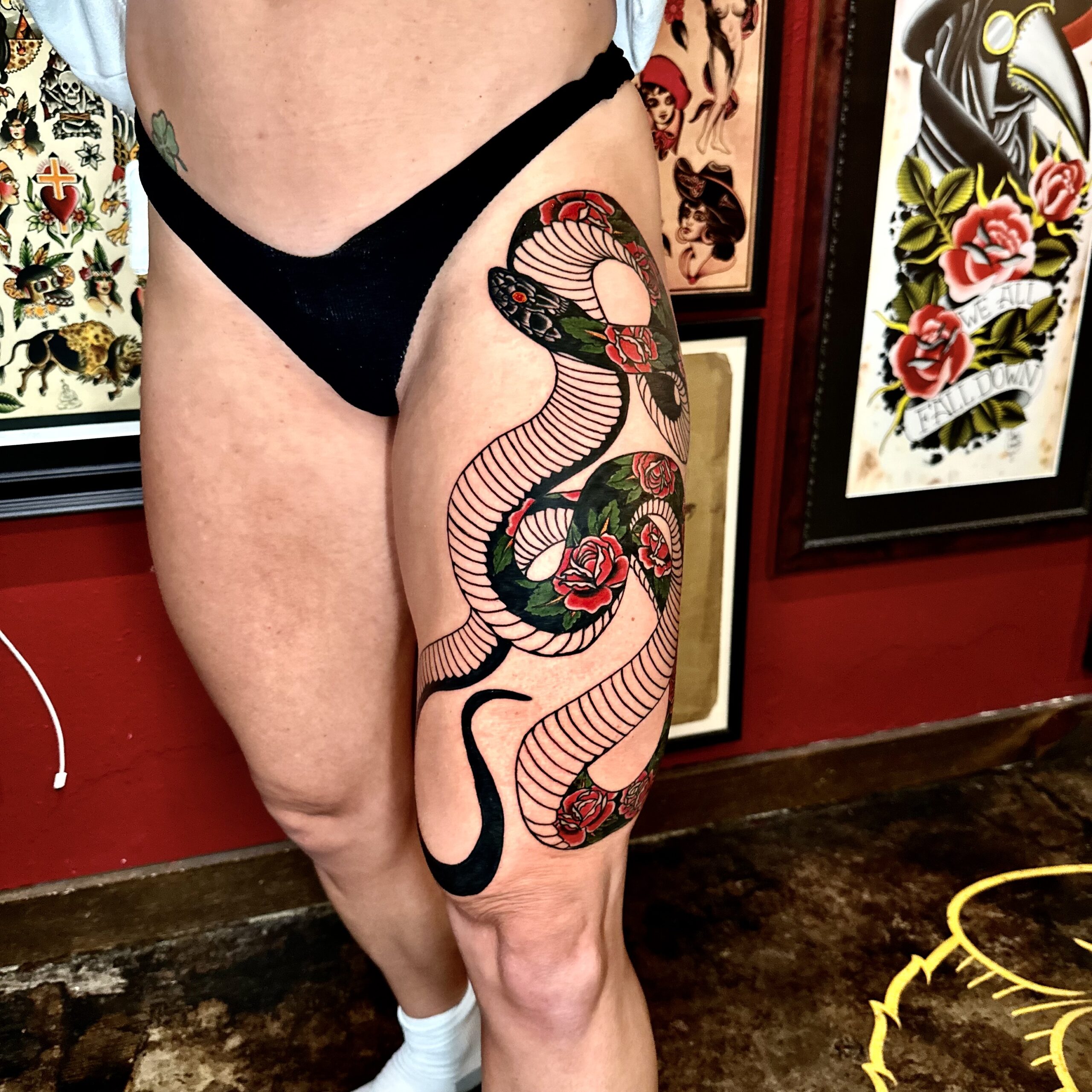 Large tattoo of a snake on a woman’s thigh