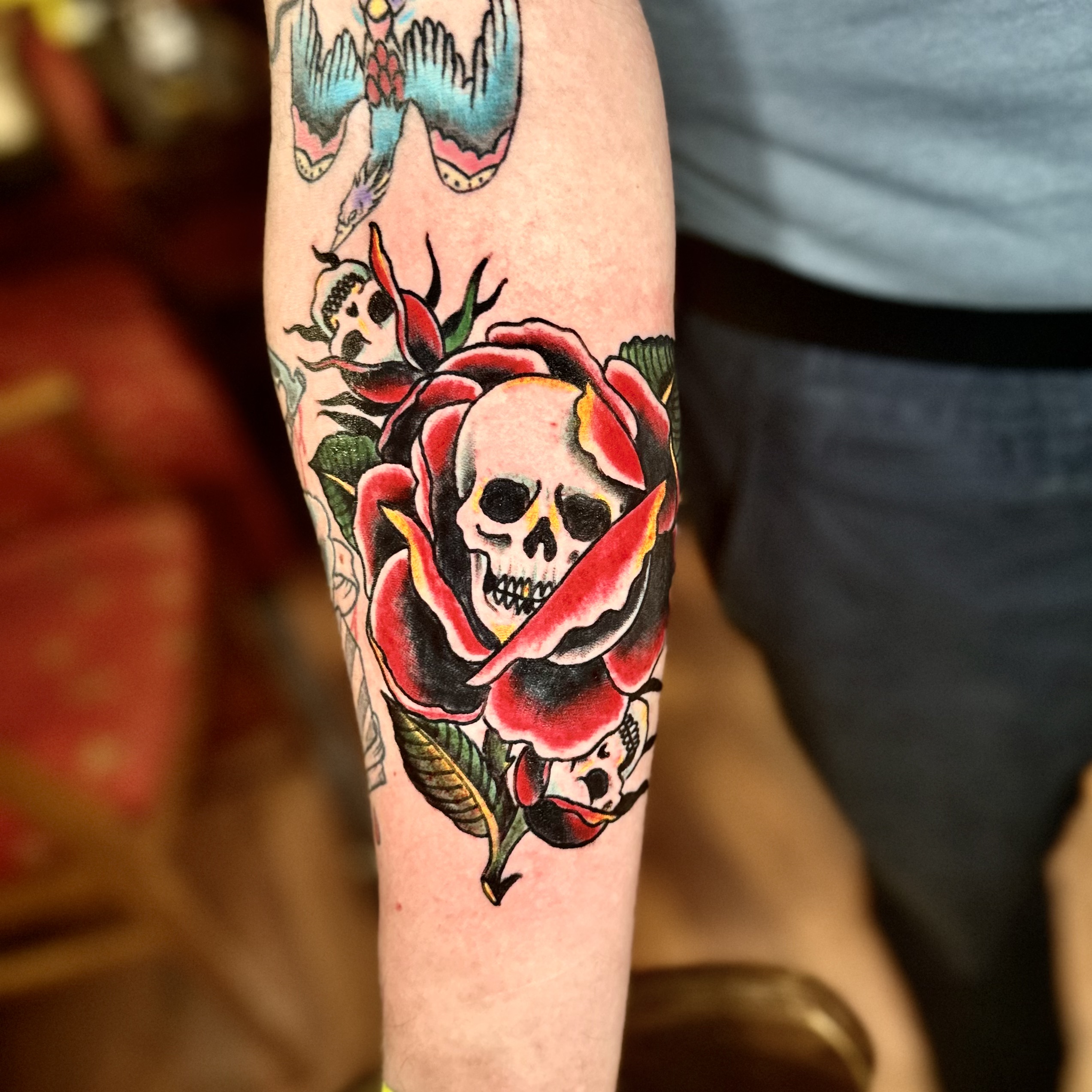 Tattoo of flowers and skulls from shop in Dallas