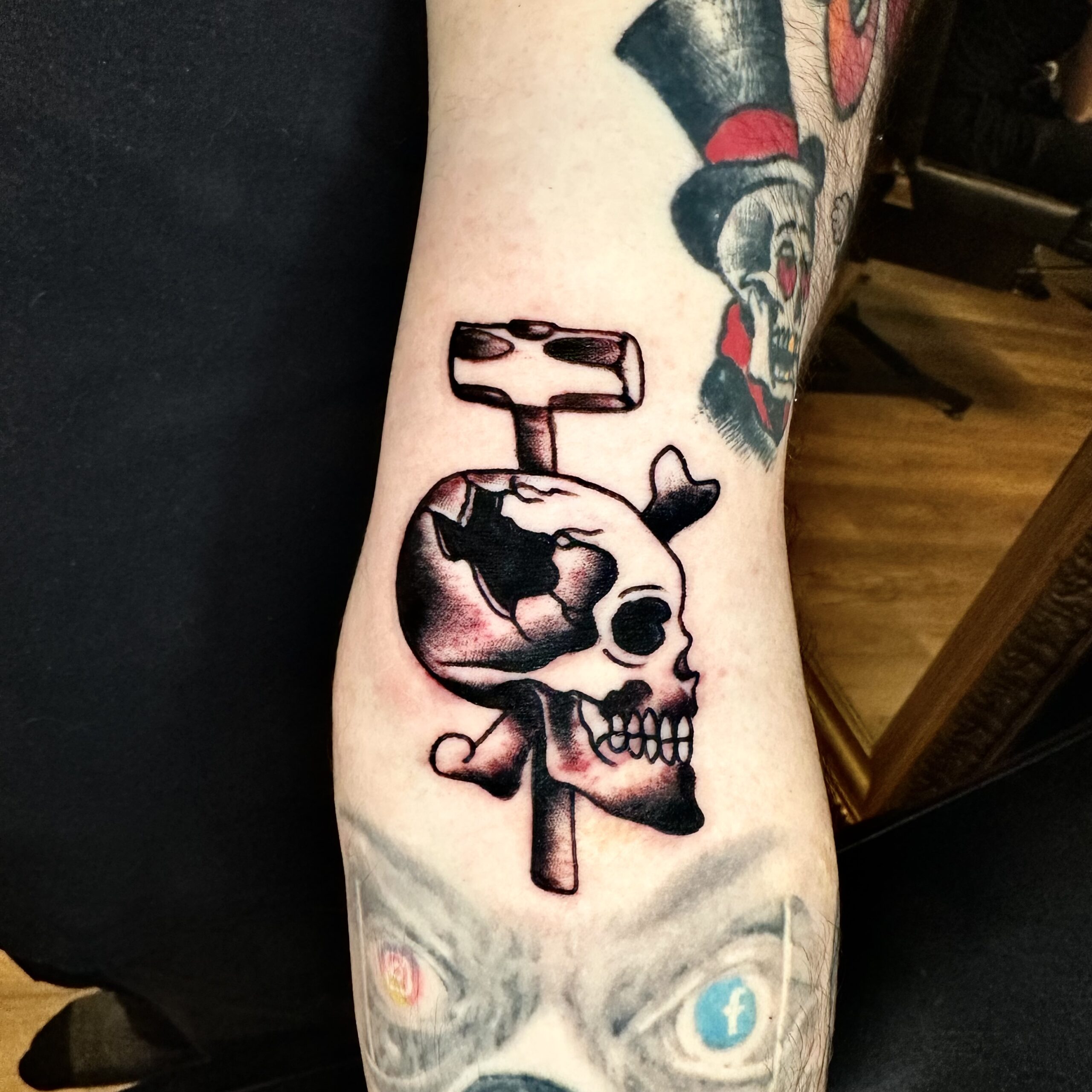 Tattoo of a skull and hammer from a Dallas tattoo shop