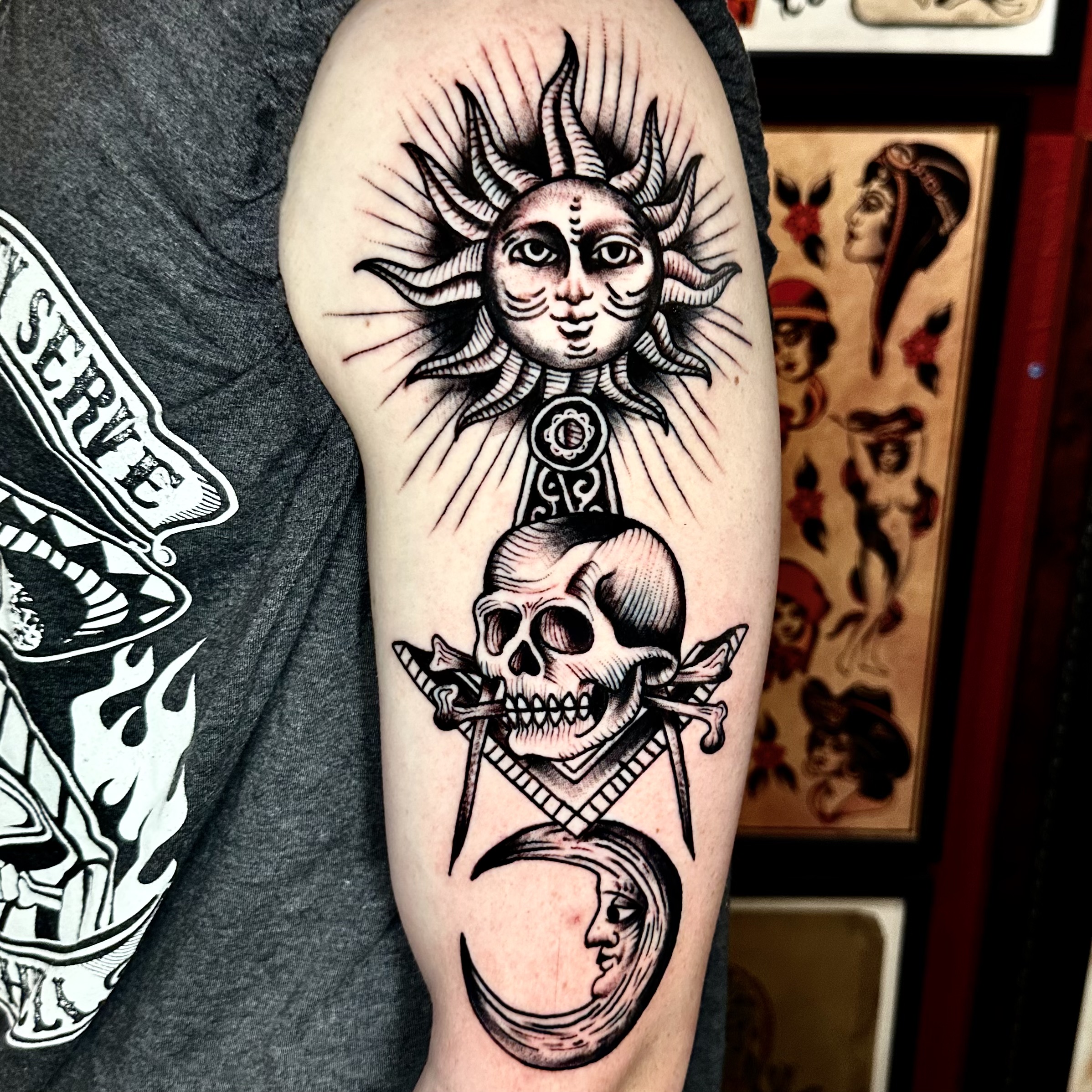 Tattoo of the sun, a skull, and the moon