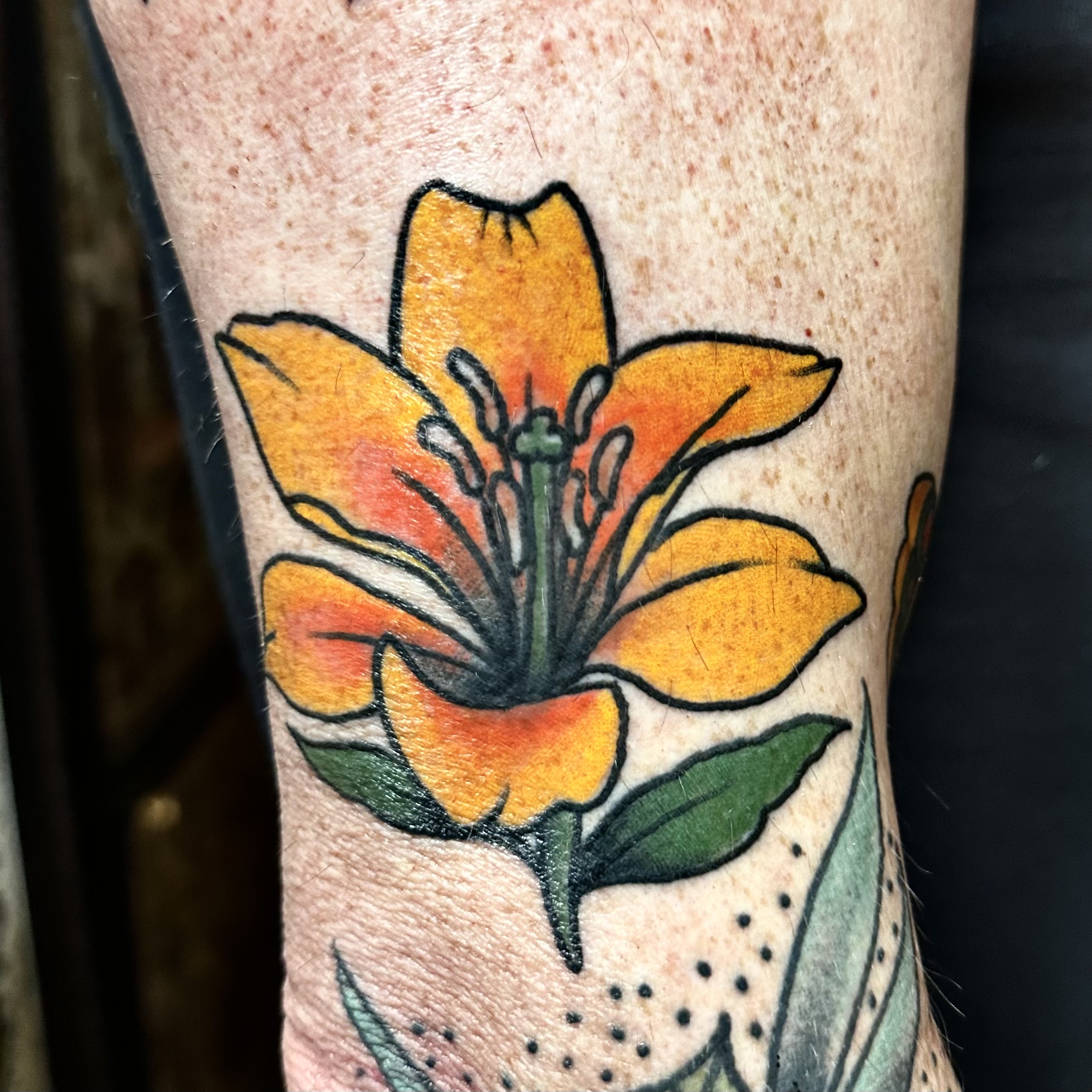 Tattoo of a yellow and orange flower