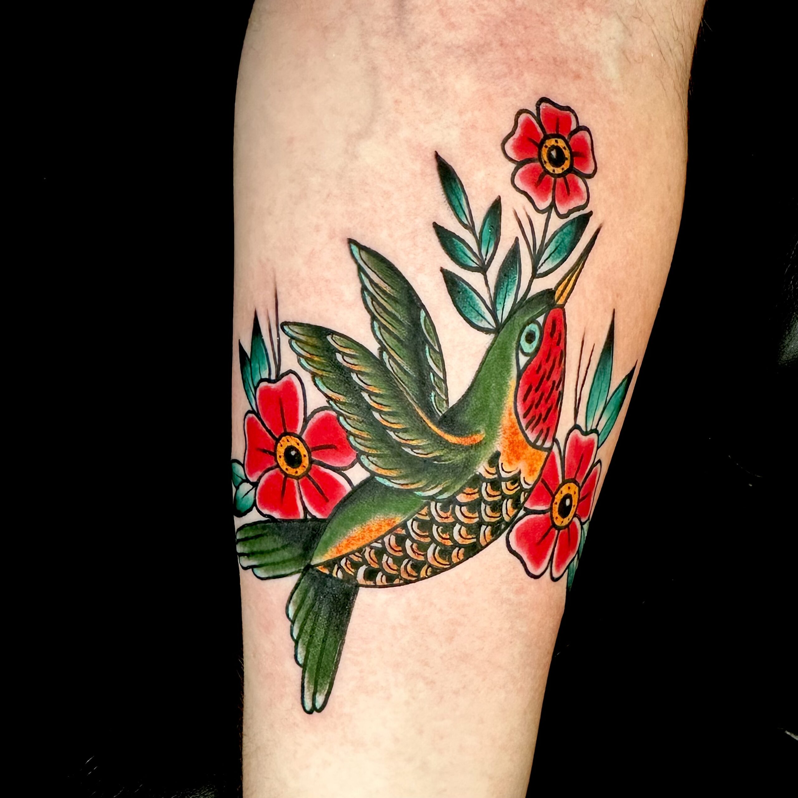 Tattoo of a hummingbird and flowers