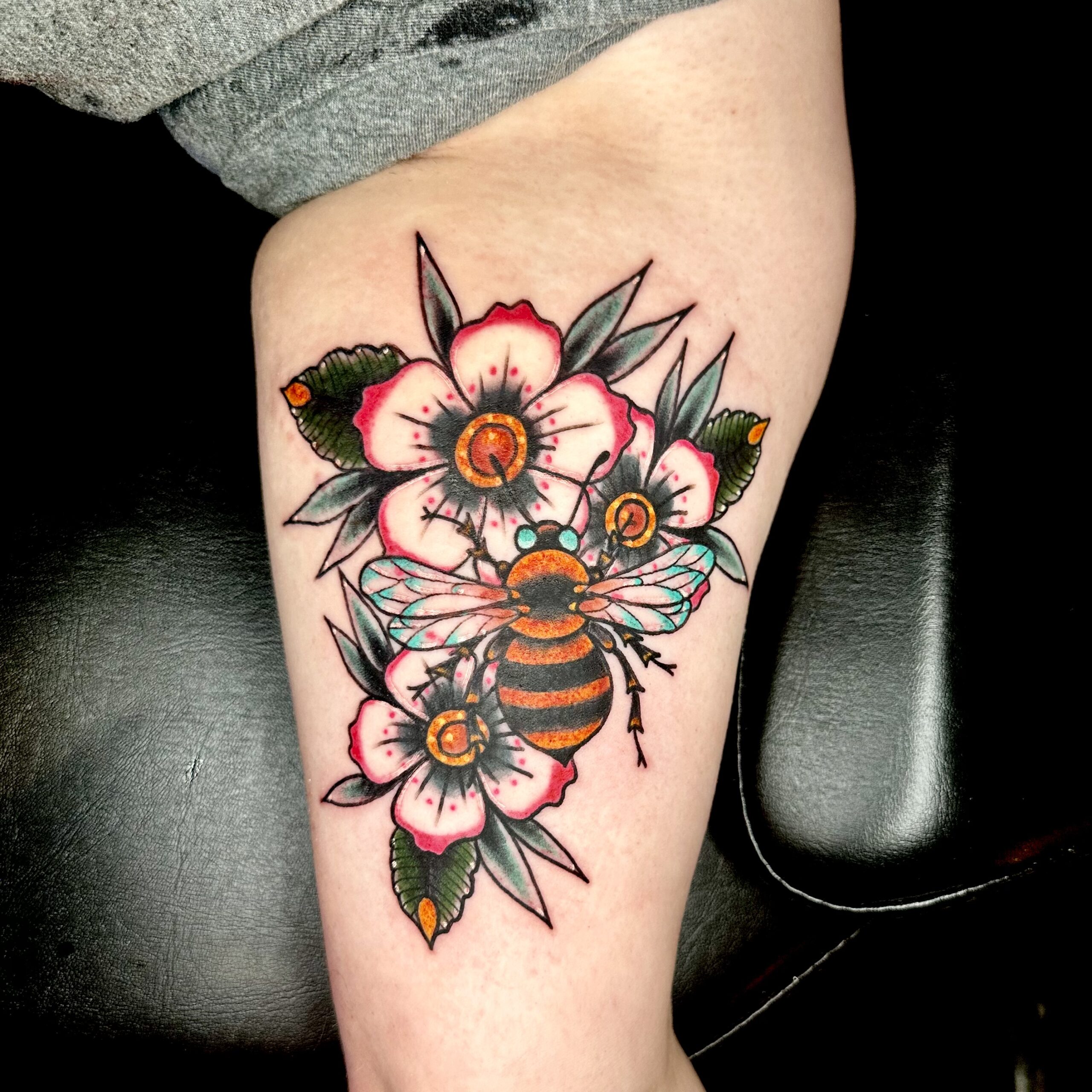 Tattoo of flowers and a bee from Dallas tattoo shop