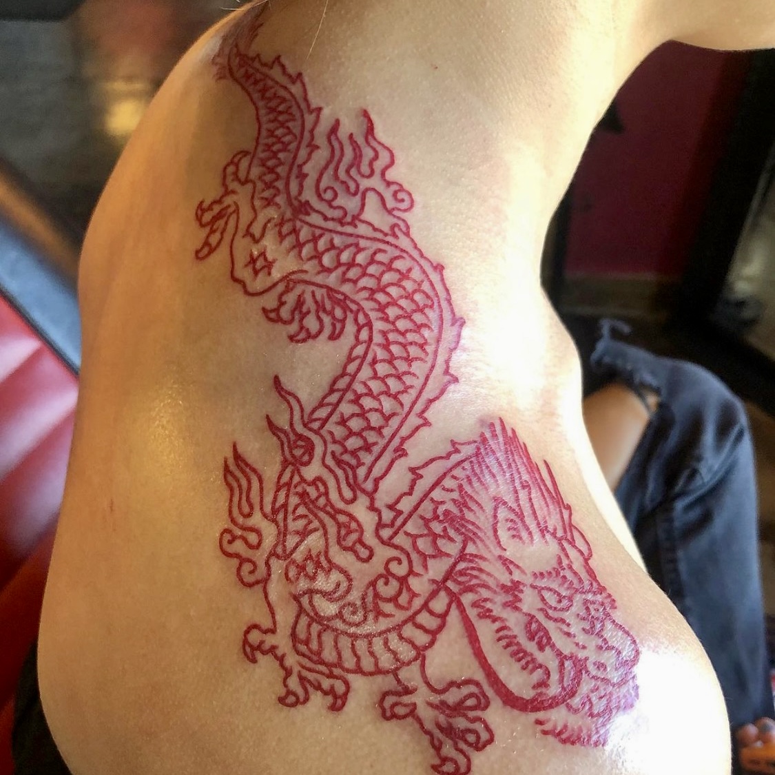Red tattoo of a dragon from top Dallas tattoo artists