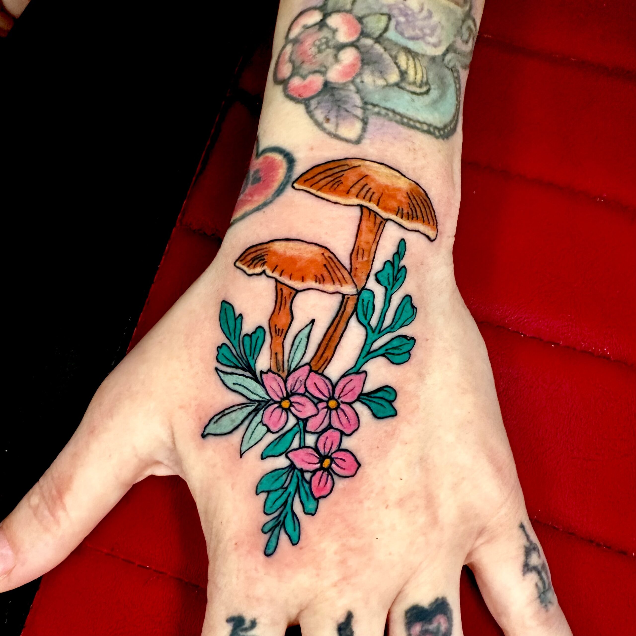 Colorful tattoo of mushrooms and flowers